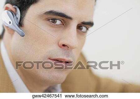 Portrait of a mid adult man wearing hands free device and thinking View Large Photo Image Stock Image - Portrait of a mid adult man wearing hands free device and thinking. Fotosearch