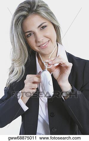 Stock Image - Portrait of a mid adult woman holding a computer mouse and smiling. Fotosearch