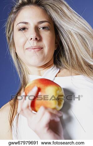 Portrait of a mid adult woman holding an apple View Large Photo Image Stock Image - Portrait of a mid adult woman holding an apple. Fotosearch
