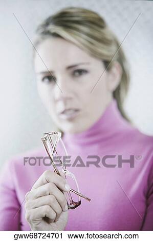 Portrait of a mid adult woman holding eyeglasses View Large Photo Image Stock Image - Portrait of a mid adult woman holding eyeglasses. Fotosearch