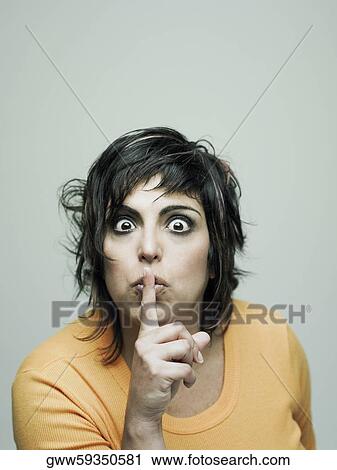 Portrait of a mid adult woman with her finger on her lips View Large Photo Image Stock Image - Portrait of a mid adult woman with her finger on her lips. Fotosearch