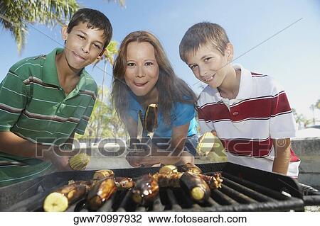 Portrait of a mid adult woman with her children at a barbecue View Large Photo Image Stock Image - Portrait of a mid adult woman with her children at a barbecue. Fotosearch