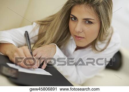 Portrait of a mid adult woman writing on a check View Large Photo Image Stock Image - Portrait of a mid adult woman writing on a check. Fotosearch