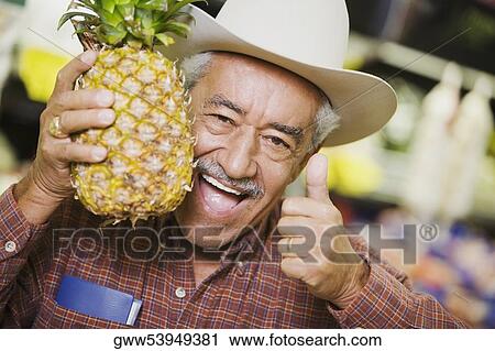 Portrait of a senior man holding a pineapple and showing a thumbs up sign View Large Photo Image Stock Image - Portrait of a senior man holding a pineapple and showing a thumbs up sign. Fotosearch