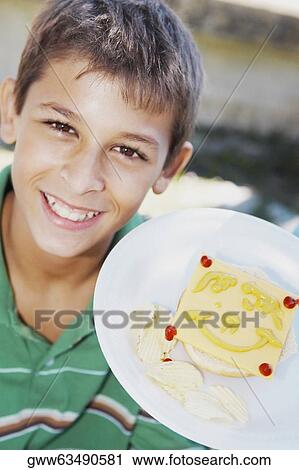 Portrait of a teenage boy showing a smiley face on a slice of cheese in a plate View Large Photo Image Stock Image - Portrait of a teenage boy showing a smiley face on a slice of cheese in a plate. Fotosearch
