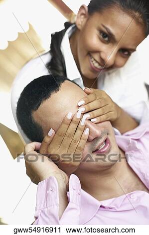 Portrait of a teenage girl covering a young man's eyes View Large Photo Image Stock Image - Portrait of a teenage girl covering a young man's eyes. Fotosearch