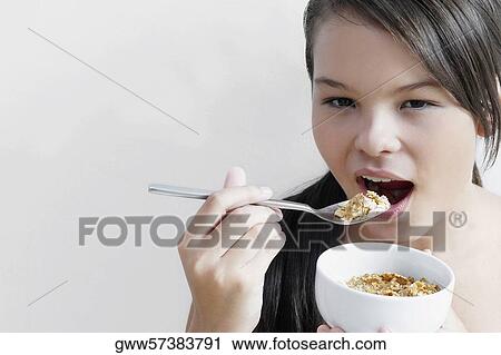 Portrait of a teenage girl eating a bowl of corn flakes View Large Photo Image Stock Image - Portrait of a teenage girl eating a bowl of corn flakes. Fotosearch