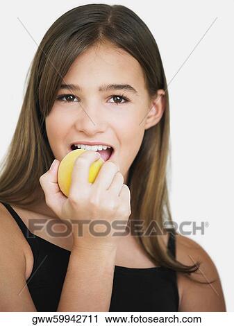 Portrait of a teenage girl eating an apple View Large Photo Image Stock Image - Portrait of a teenage girl eating an apple. Fotosearch