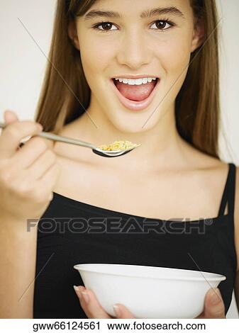 Portrait of a teenage girl eating cornflakes with a spoon View Large Photo Image Stock Image - Portrait of a teenage girl eating cornflakes with a spoon. Fotosearch