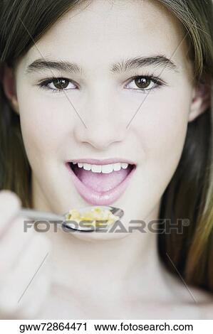 Portrait of a teenage girl eating cornflakes with a spoon View Large Photo Image Stock Image - Portrait of a teenage girl eating cornflakes with a spoon. Fotosearch