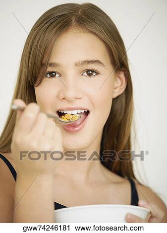 Portrait of a teenage girl eating cornflakes with a spoon View Large Photo Image Stock Image - Portrait of a teenage girl eating cornflakes with a spoon. Fotosearch