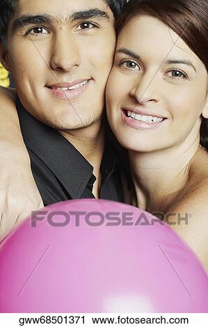 Stock Image - Portrait of a young couple embracing each other. Fotosearch