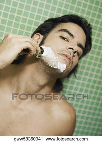 Portrait of a young man applying shaving cream on his face View Large Photo Image Stock Image - Portrait of a young man applying shaving cream on his face. Fotosearch