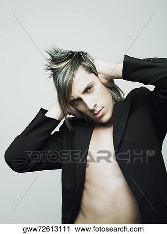 Stock Image - Portrait of a young man covering his ears with his hands. Fotosearch