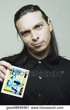 Portrait of a young man holding a playing card View Large Photo Image Stock Image - Portrait of a young man holding a playing card. Fotosearch