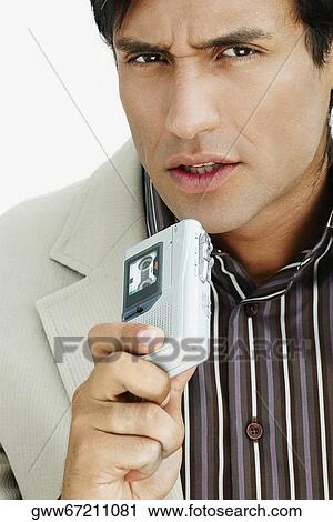 Portrait of a young man holding a Dictaphone View Large Photo Image Stock Image - Portrait of a young man holding a Dictaphone. Fotosearch