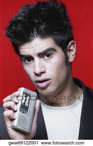 Portrait of a young man holding a Dictaphone View Large Photo Image Stock Image - Portrait of a young man holding a Dictaphone. Fotosearch