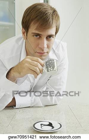 Portrait of a young man holding a coffee cup View Large Photo Image Stock Image - Portrait of a young man holding a coffee cup. Fotosearch