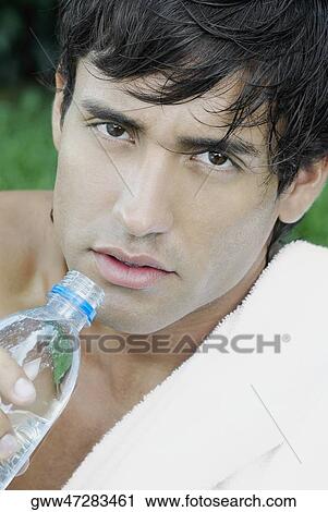 Portrait of a young man holding a water bottle View Large Photo Image Stock Image - Portrait of a young man holding a water bottle. Fotosearch