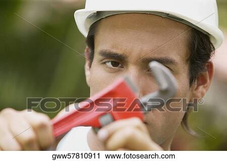 Portrait of a young man holding an adjustable wrench View Large Photo Image Stock Image - Portrait of a young man holding an adjustable wrench. Fotosearch