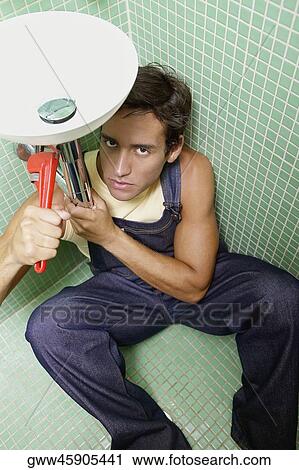 Portrait of a young man repairing a washbasin View Large Photo Image Stock Image - Portrait of a young man repairing a washbasin. Fotosearch