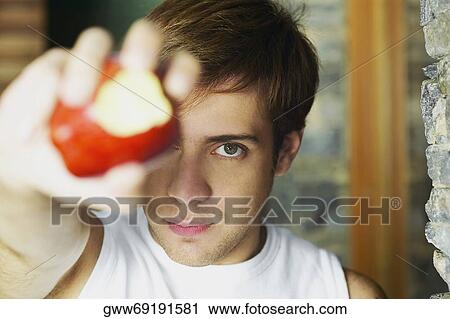 Portrait of a young man showing a partially eaten apple View Large Photo Image Stock Image - Portrait of a young man showing a partially eaten apple. Fotosearch