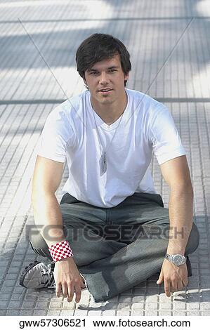 Portrait of a young man sitting on the floor View Large Photo Image Stock Image - Portrait of a young man sitting on the floor. Fotosearch