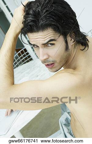 Portrait of a young man sitting with his hand in his hair View Large Photo Image Stock Image - Portrait of a young man sitting with his hand in his hair. Fotosearch