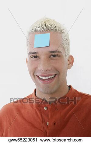 Portrait of a young man smiling with an adhesive note on his forehead View Large Photo Image Stock Image - Portrait of a young man smiling with an adhesive note on his forehead. Fotosearch