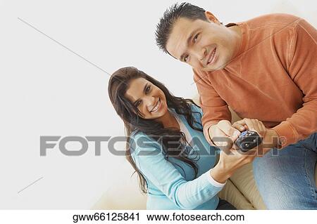 Portrait of a young woman and a mid adult man operating a remote control View Large Photo Image Stock Image - Portrait of a young woman and a mid adult man operating a remote control. Fotosearch