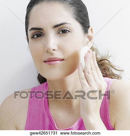 Portrait of a young woman applying face powder on her cheeks View Large Photo Image Stock Image - Portrait of a young woman applying face powder on her cheeks. Fotosearch