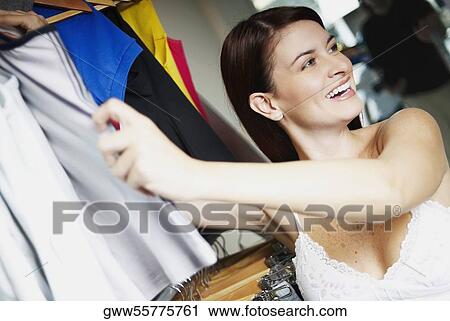 Portrait of a young woman choosing clothes in a clothing store View Large Photo Image Stock Image - Portrait of a young woman choosing clothes in a clothing store. Fotosearch