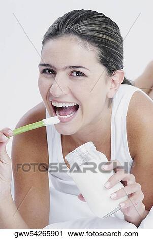 Portrait of a young woman eating a stick of celery View Large Photo Image Stock Image - Portrait of a young woman eating a stick of celery. Fotosearch