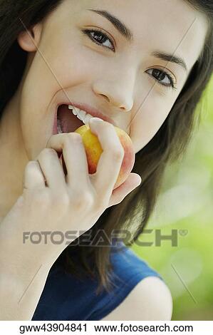 Portrait of a young woman eating an apple View Large Photo Image Stock Image - Portrait of a young woman eating an apple. Fotosearch