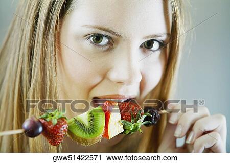 Portrait of a young woman eating fruit salad View Large Photo Image Stock Image - Portrait of a young woman eating fruit salad. Fotosearch