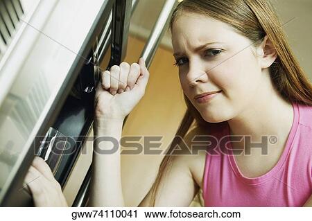 Portrait of a young woman filling the glass from a water cooler View Large Photo Image Stock Image - Portrait of a young woman filling the glass from a water cooler. Fotosearch