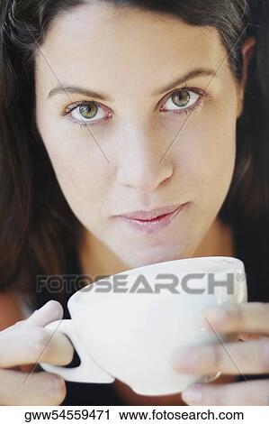 Portrait of a young woman holding a cup View Large Photo Image Stock Image - Portrait of a young woman holding a cup. Fotosearch