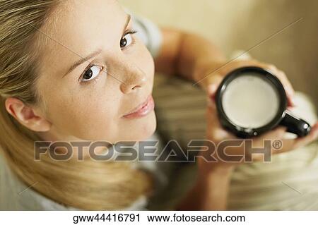 Portrait of a young woman holding a coffee cup View Large Photo Image Stock Image - Portrait of a young woman holding a coffee cup. Fotosearch