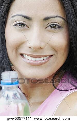 Portrait of a young woman holding a water bottle View Large Photo Image Stock Image - Portrait of a young woman holding a water bottle. Fotosearch