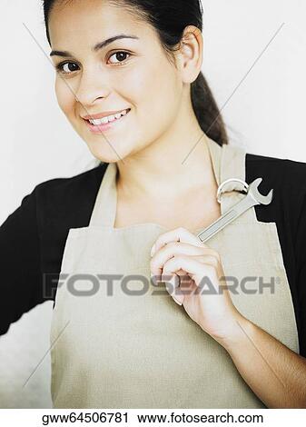 Portrait of a young woman holding a wrench View Large Photo Image Stock Image - Portrait of a young woman holding a wrench. Fotosearch