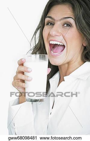 Portrait of a young woman holding a glass of milk View Large Photo Image Stock Image - Portrait of a young woman holding a glass of milk. Fotosearch