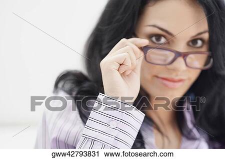 Portrait of a young woman holding her eyeglasses View Large Photo Image Stock Image - Portrait of a young woman holding her eyeglasses. Fotosearch