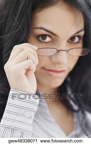 Portrait of a young woman holding her eyeglasses View Large Photo Image Stock Image - Portrait of a young woman holding her eyeglasses. Fotosearch