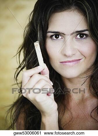 Portrait of a young woman holding snacks and making a face View Large Photo Image Stock Image - Portrait of a young woman holding snacks and making a face. Fotosearch