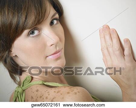 Portrait of a young woman leaning against a wall View Large Photo Image Stock Image - Portrait of a young woman leaning against a wall. Fotosearch