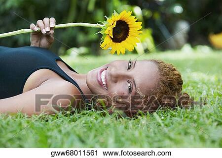 Portrait of a young woman lying in a park and smiling View Large Photo Image Stock Image - Portrait of a young woman lying in a park and smiling. Fotosearch