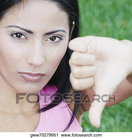 Portrait of a young woman showing a thumbs down sign View Large Photo Image Stock Image - Portrait of a young woman showing a thumbs down sign. Fotosearch