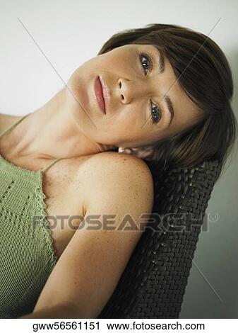 Portrait of a young woman sitting on a chair View Large Photo Image Stock Image - Portrait of a young woman sitting on a chair. Fotosearch