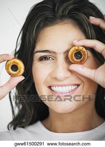 Portrait of a young woman smiling and holding two hollow cookies View Large Photo Image Stock Image - Portrait of a young woman smiling and holding two hollow cookies. Fotosearch