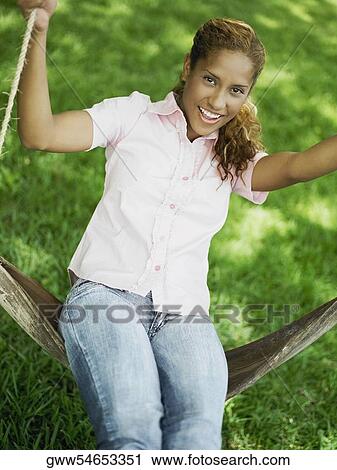 Portrait of a young woman swinging on a swing View Large Photo Image Stock Image - Portrait of a young woman swinging on a swing. Fotosearch